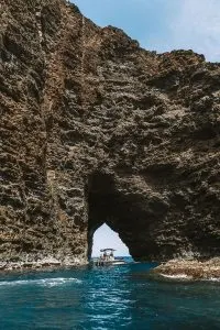 Boat going through Sea Cave along Kauai's Na Pali Coast