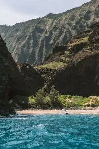 Boat docked on a pristine beach on the Na Pali Coast in Kauai