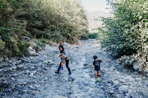 Family crossing creek in Forest Falls, California