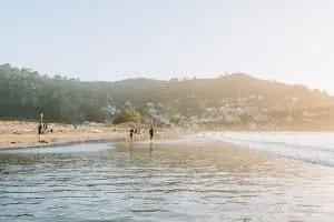 People walking along the water at Linda Mar Beach
