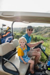 Father and son golfing at Bully Pulpit Golf Course in Medora